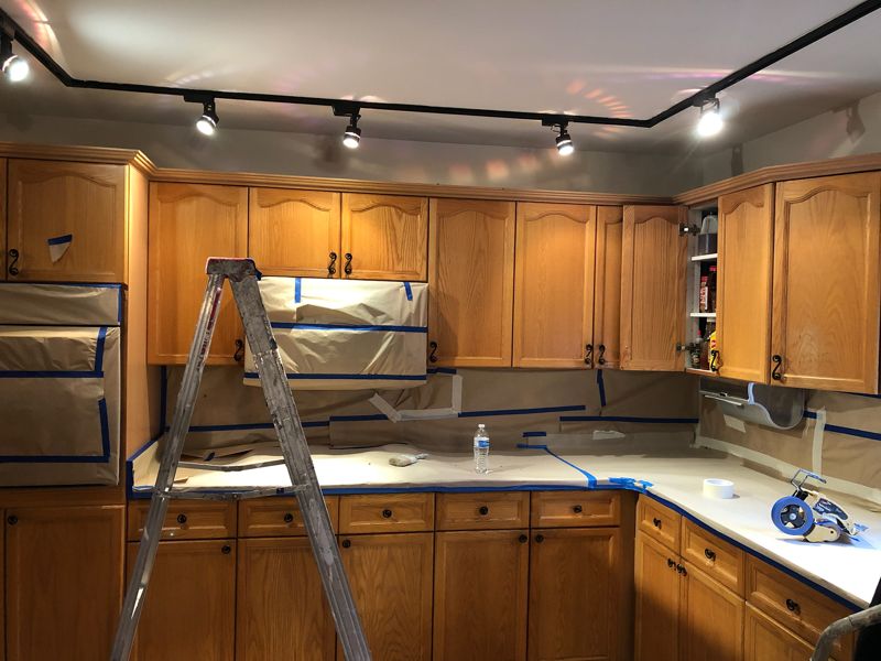 Before: oak cabinets, kitchen masked for painting